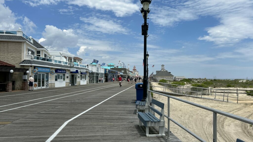 Boardwalk with shops to the left and the beach to the right.