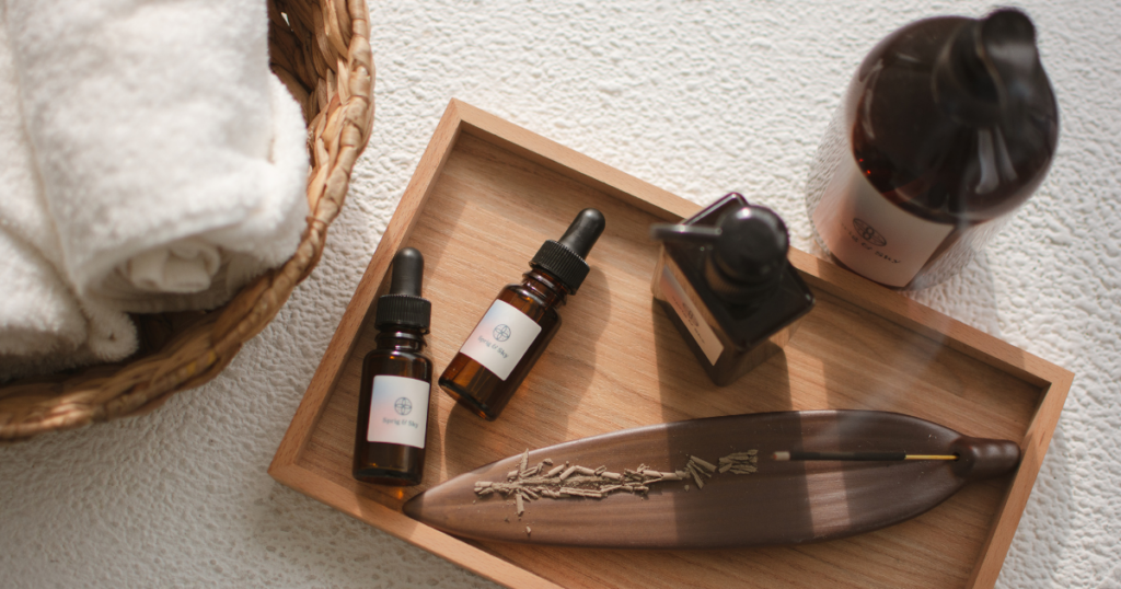 Essential oils next to burning incense near a basket of towels